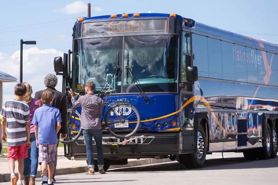 Passengers boarding a blue Flatiron Flyer BRT bus in Denver, Colorado.